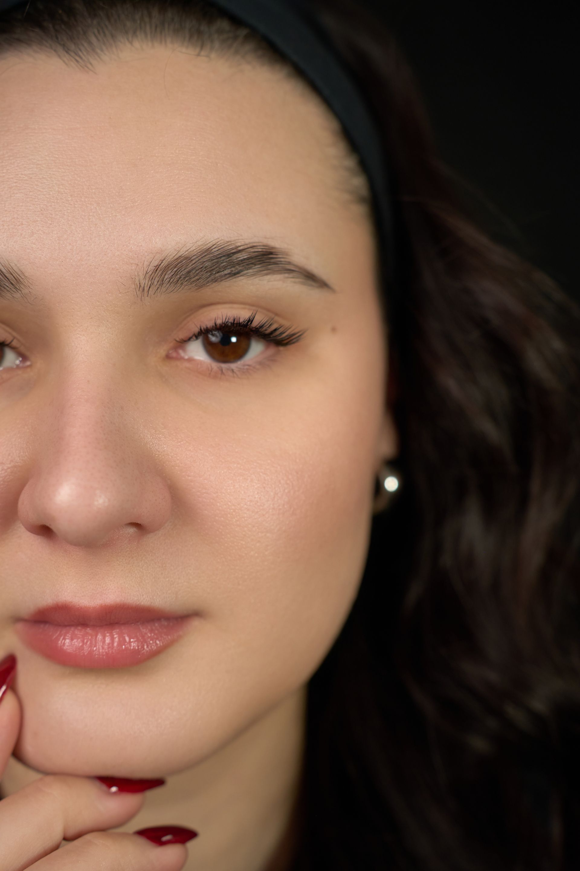A close up of a woman 's face with her hand on her chin.