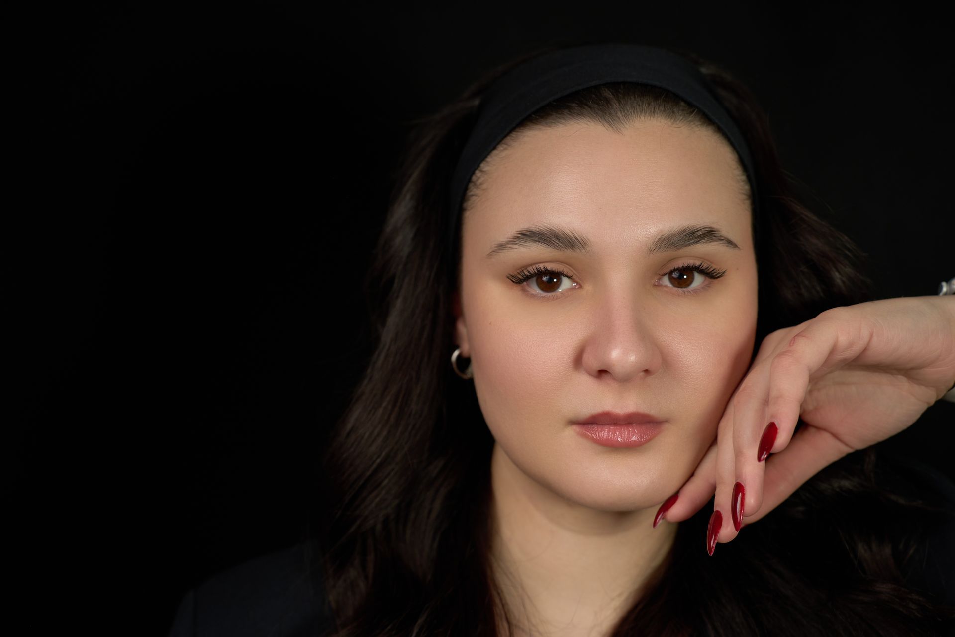 A close up of a woman 's face with her hand on her chin.