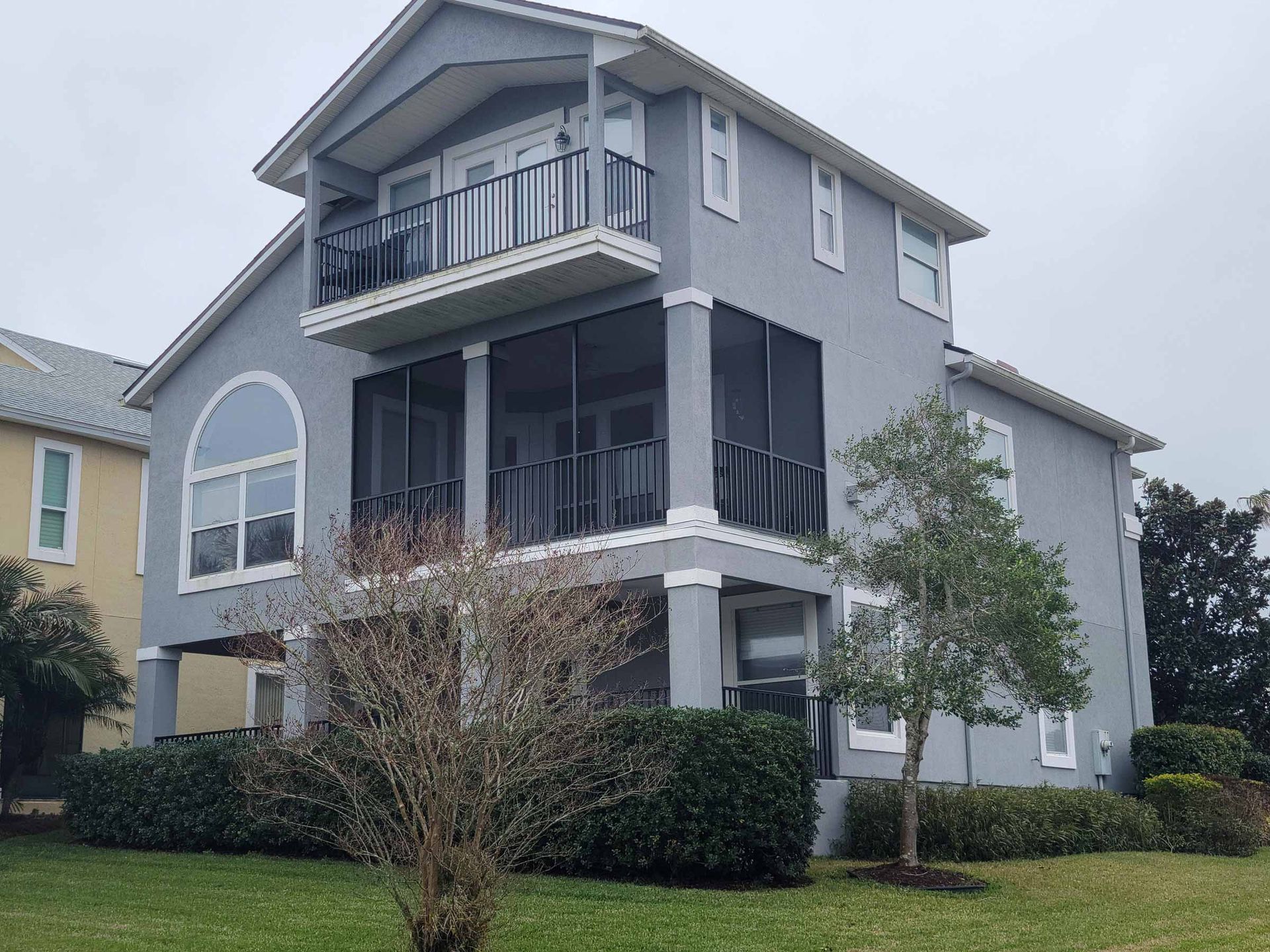 A large house with a screened in porch and balcony