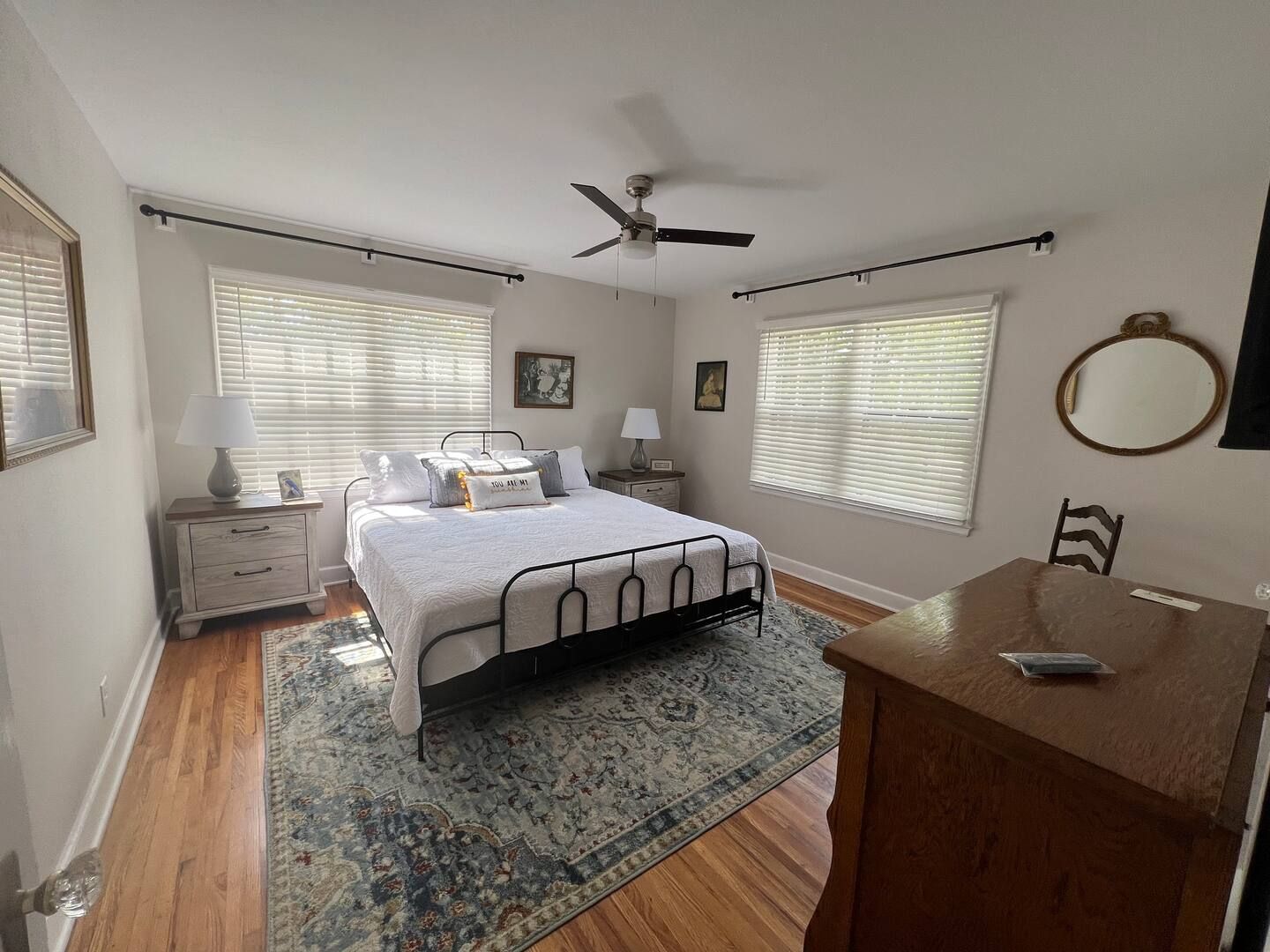A bedroom with a large bed and a ceiling fan.