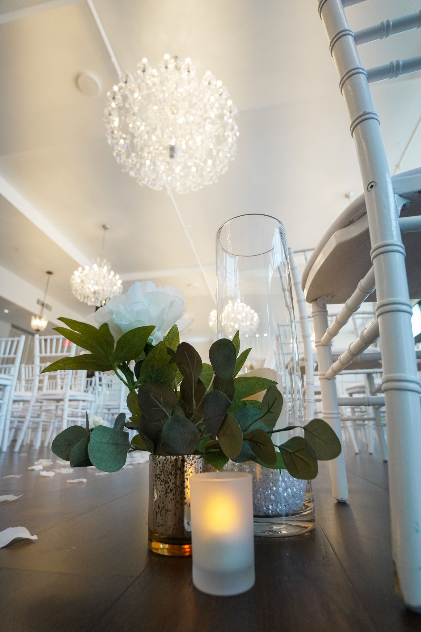 A table with a vase of flowers and candles on it.