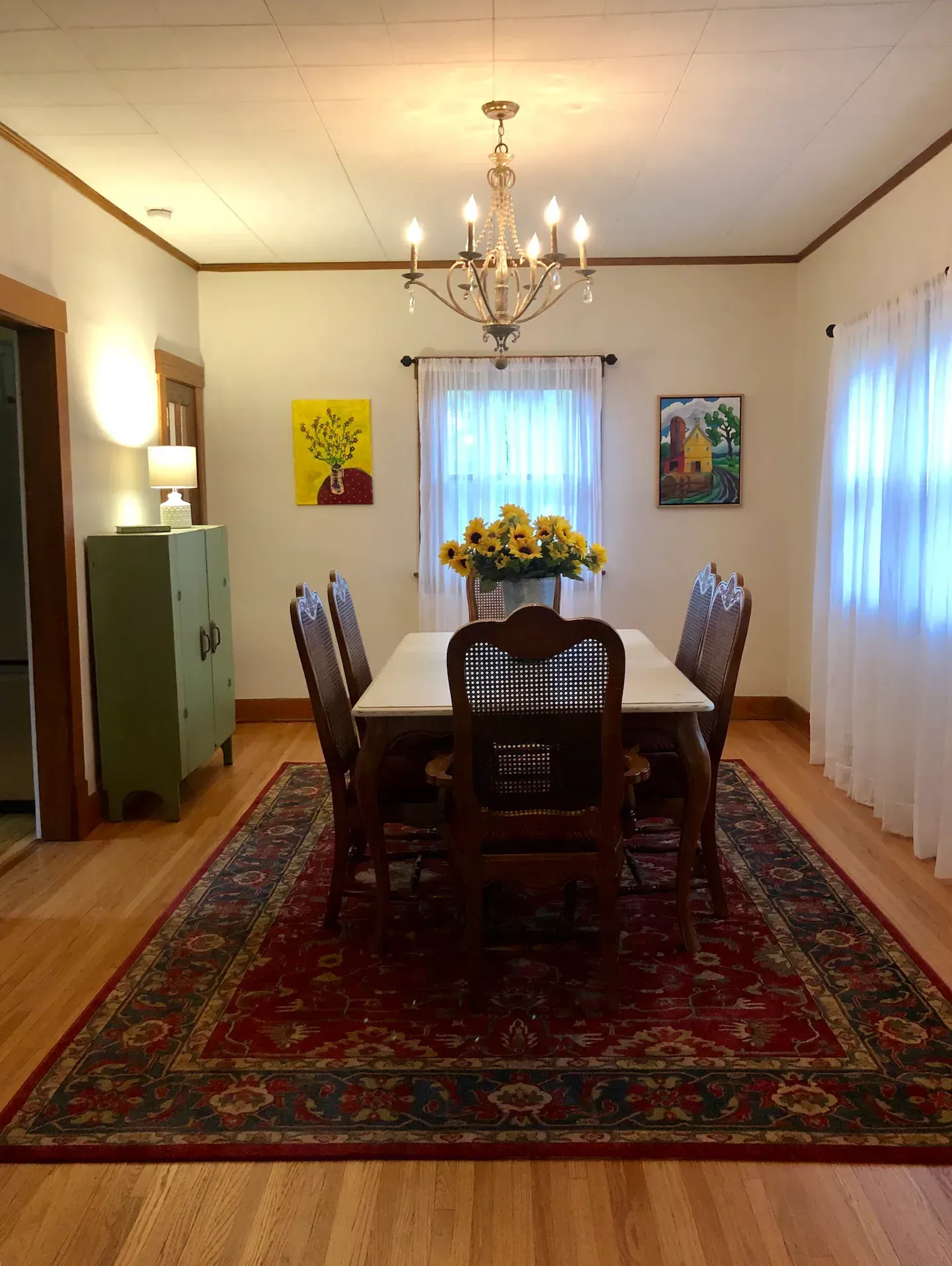 A dining room with a table and chairs and a rug