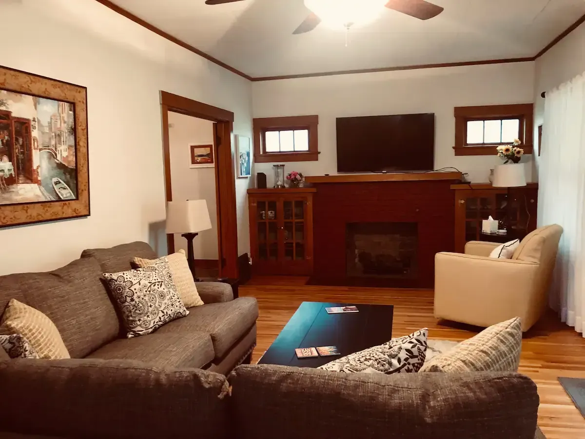 A living room with a couch a chair a television and a fireplace