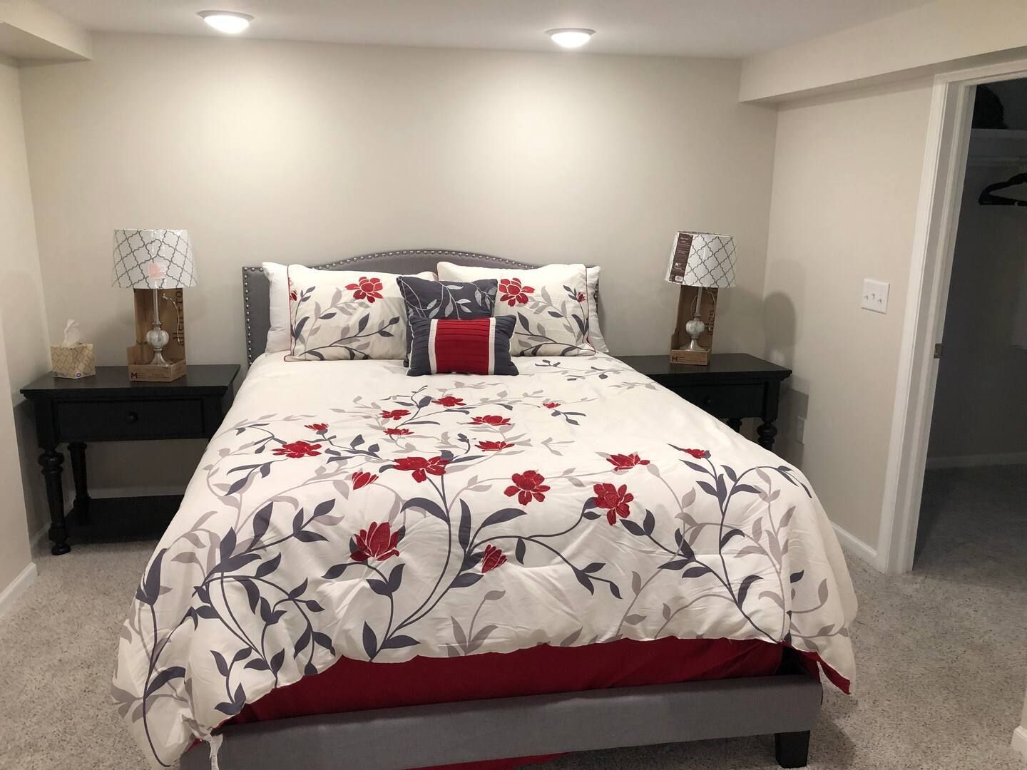 A bedroom with a bed , two nightstands and two lamps.