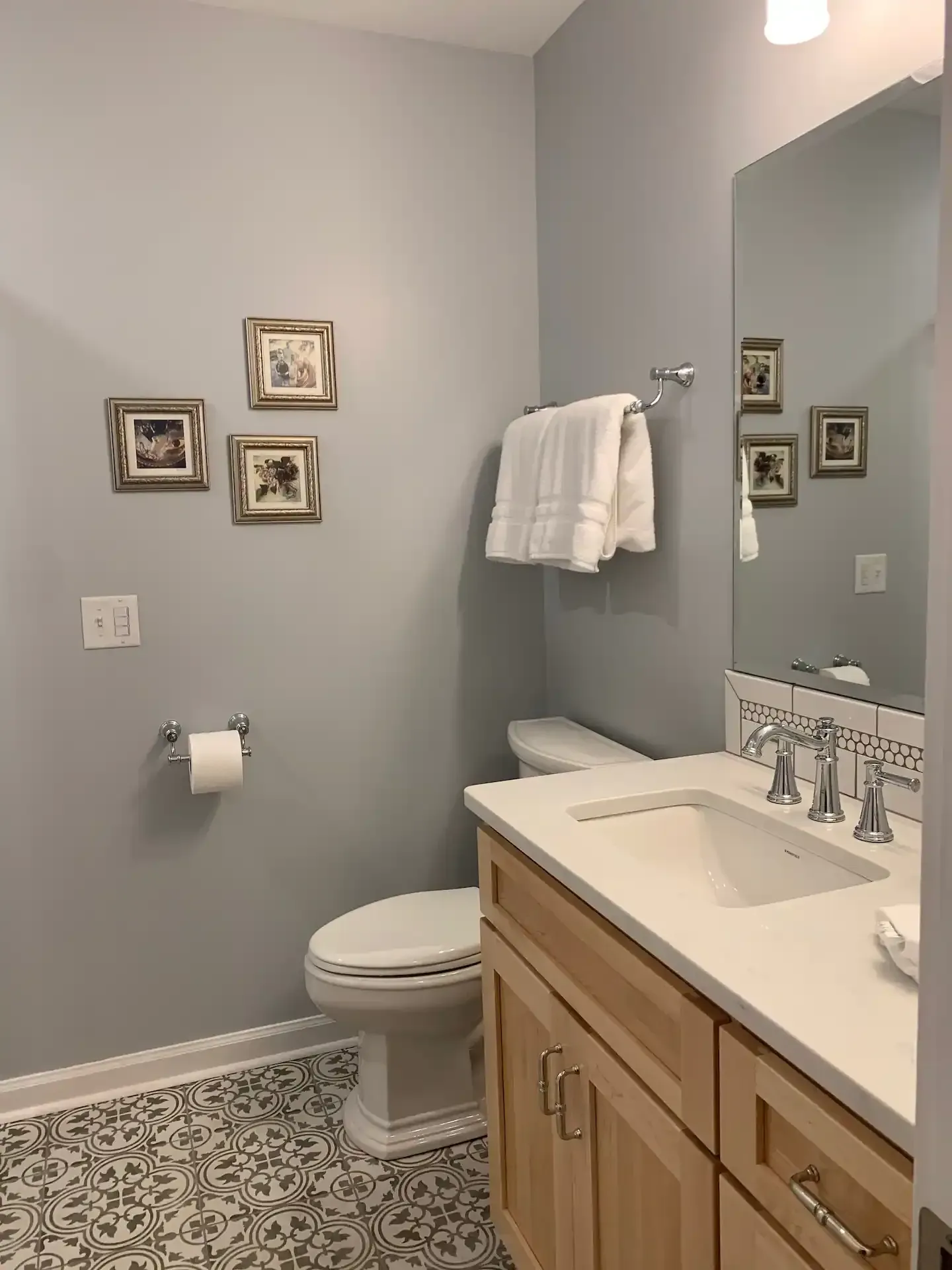 A bathroom with a toilet a sink and a mirror