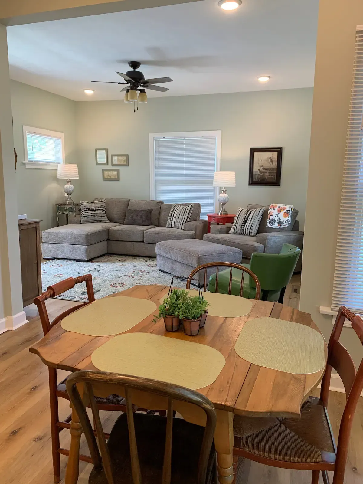 A living room with a table and chairs and lamps.