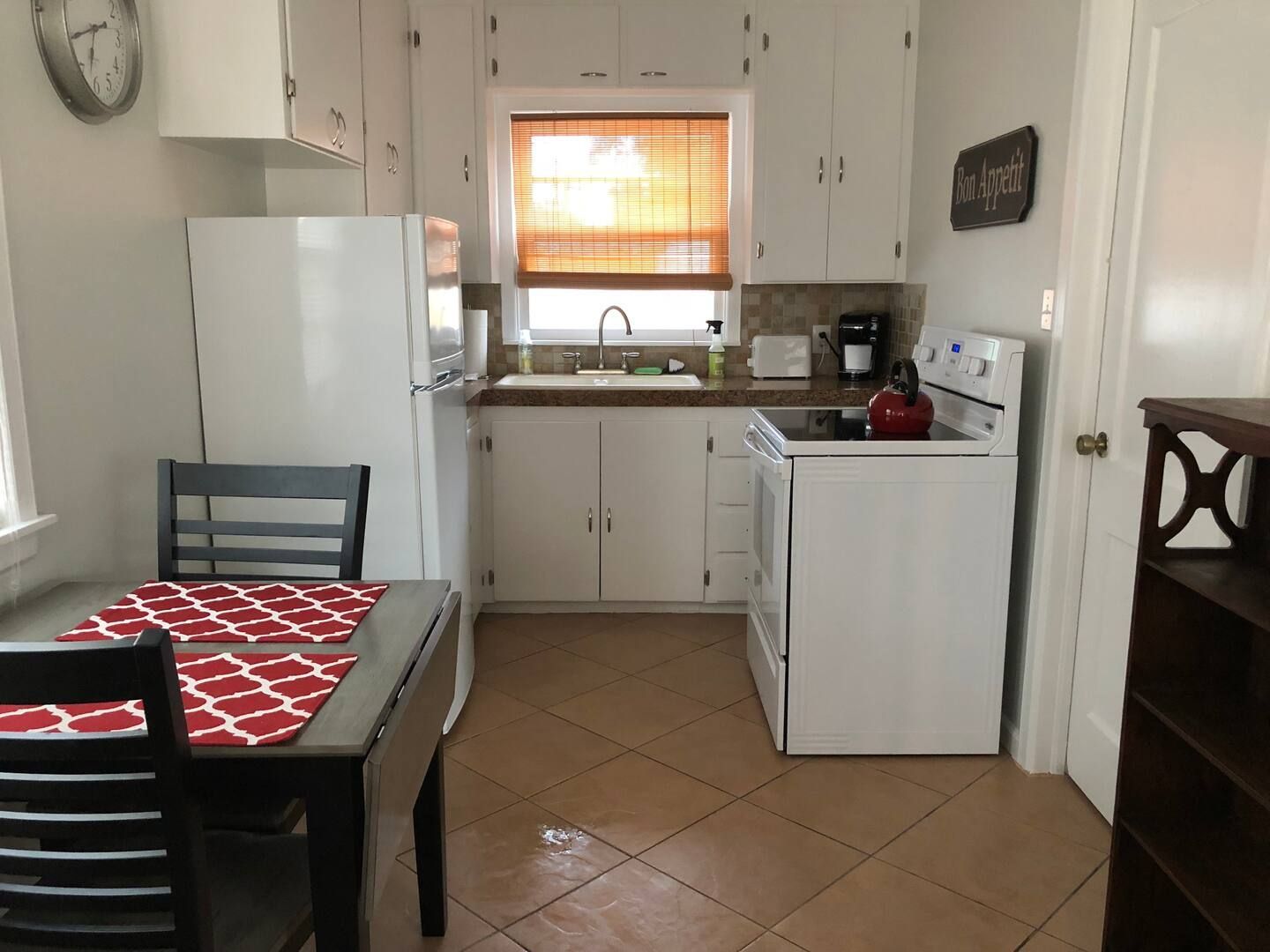 A kitchen with a table and chairs.