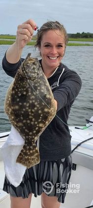 A woman is holding a fish in her hands on a boat.