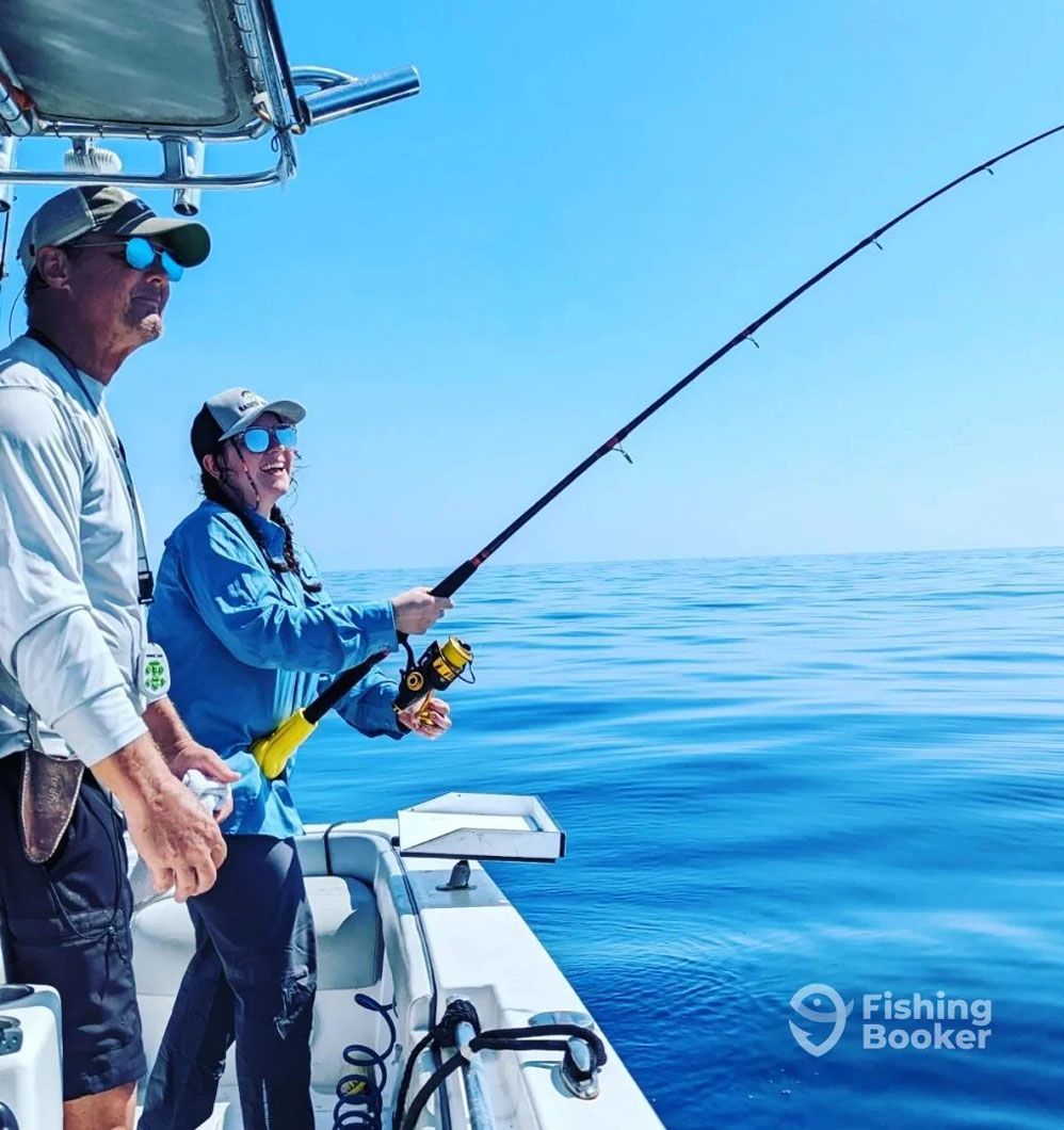 Two men are fishing on a boat in the ocean.