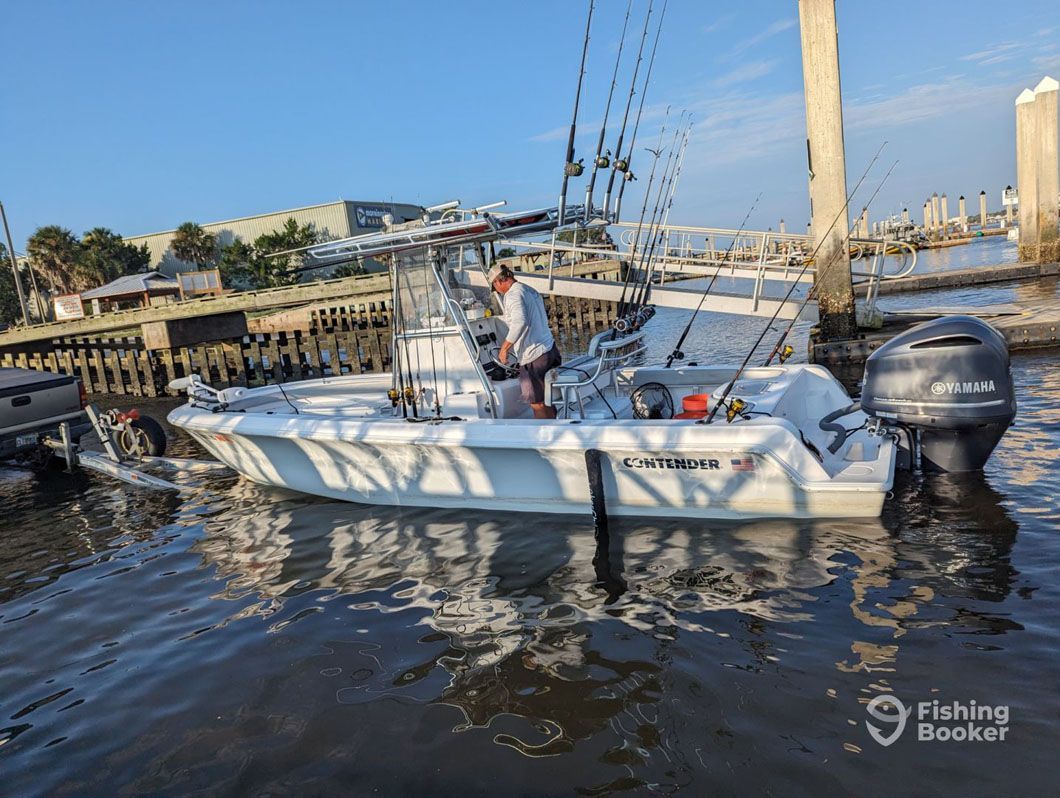 A man is fishing on a boat in the water.