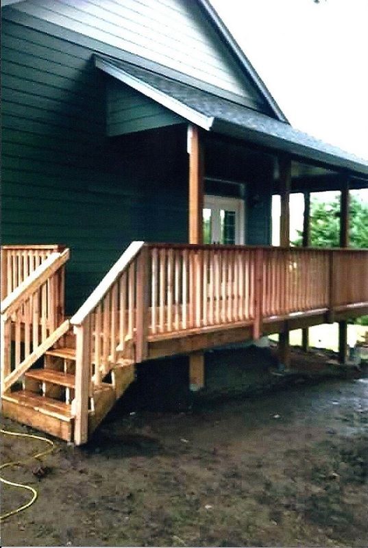 Wooden deck and steps leading to a green house with a covered porch.