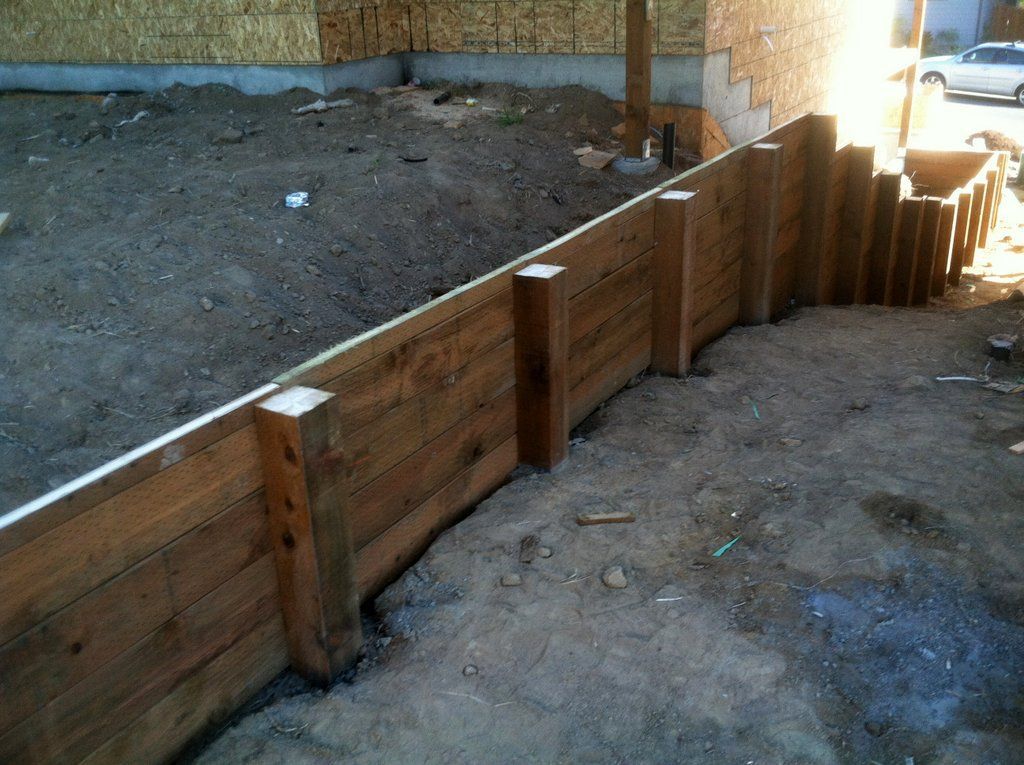 Wooden retaining wall under construction.