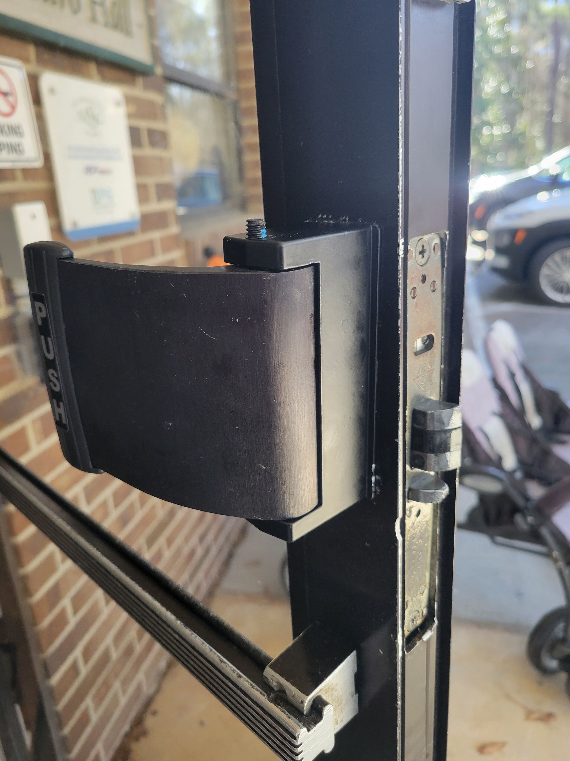 A close up of a door with a stroller in the background.