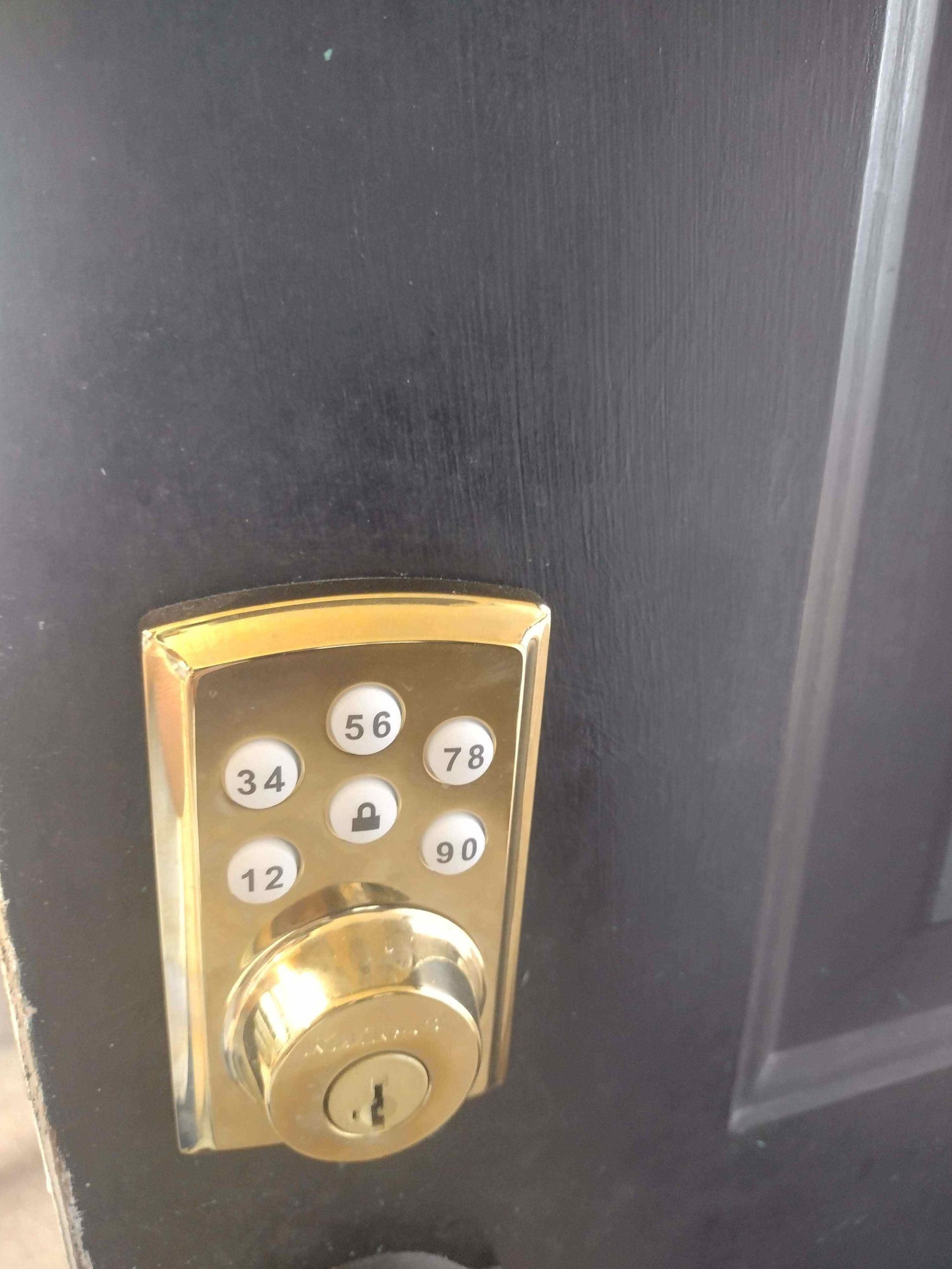 A close up of a digital door lock on a black door.