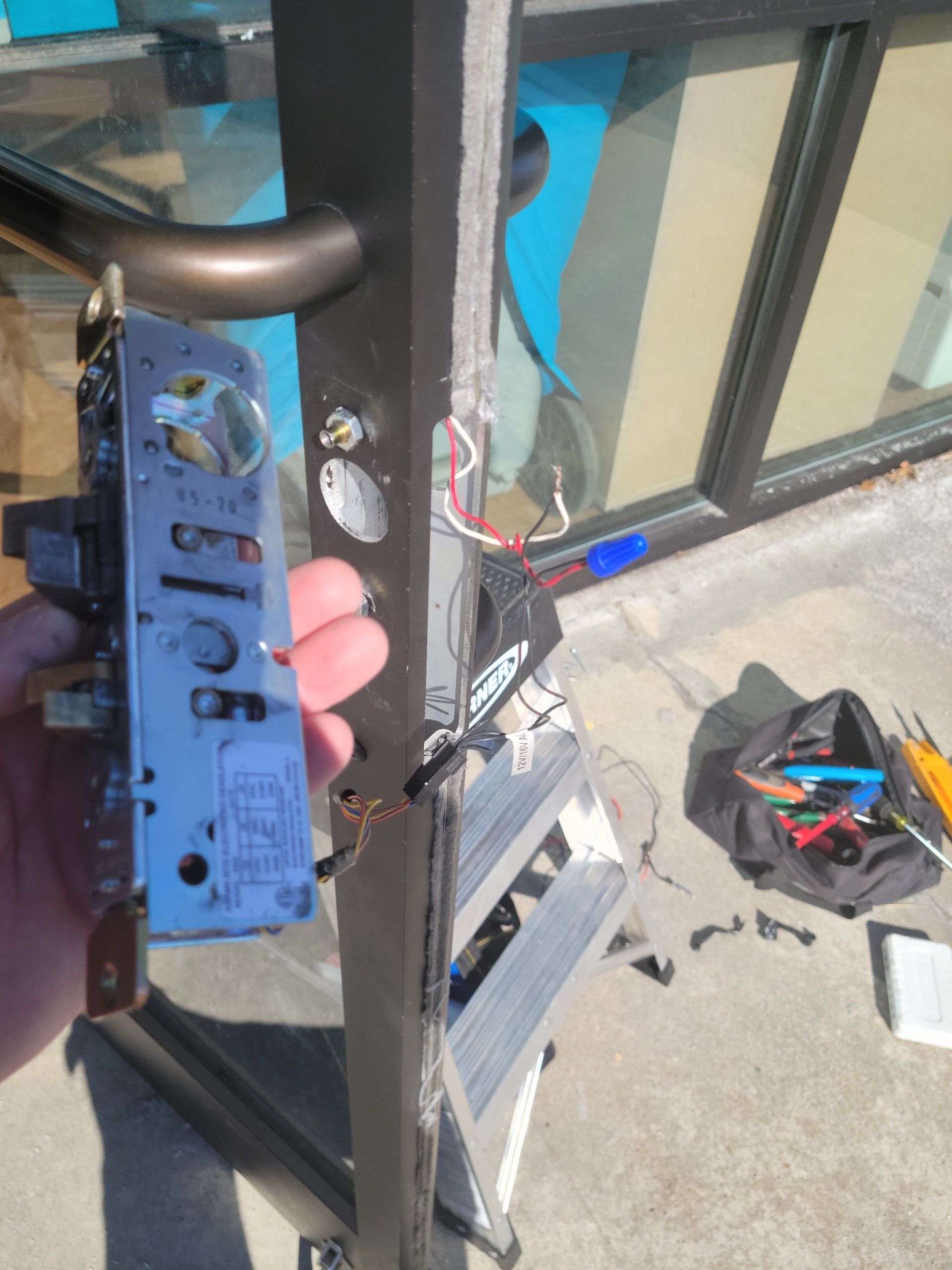 A person is holding a door lock with the number 51106 on it