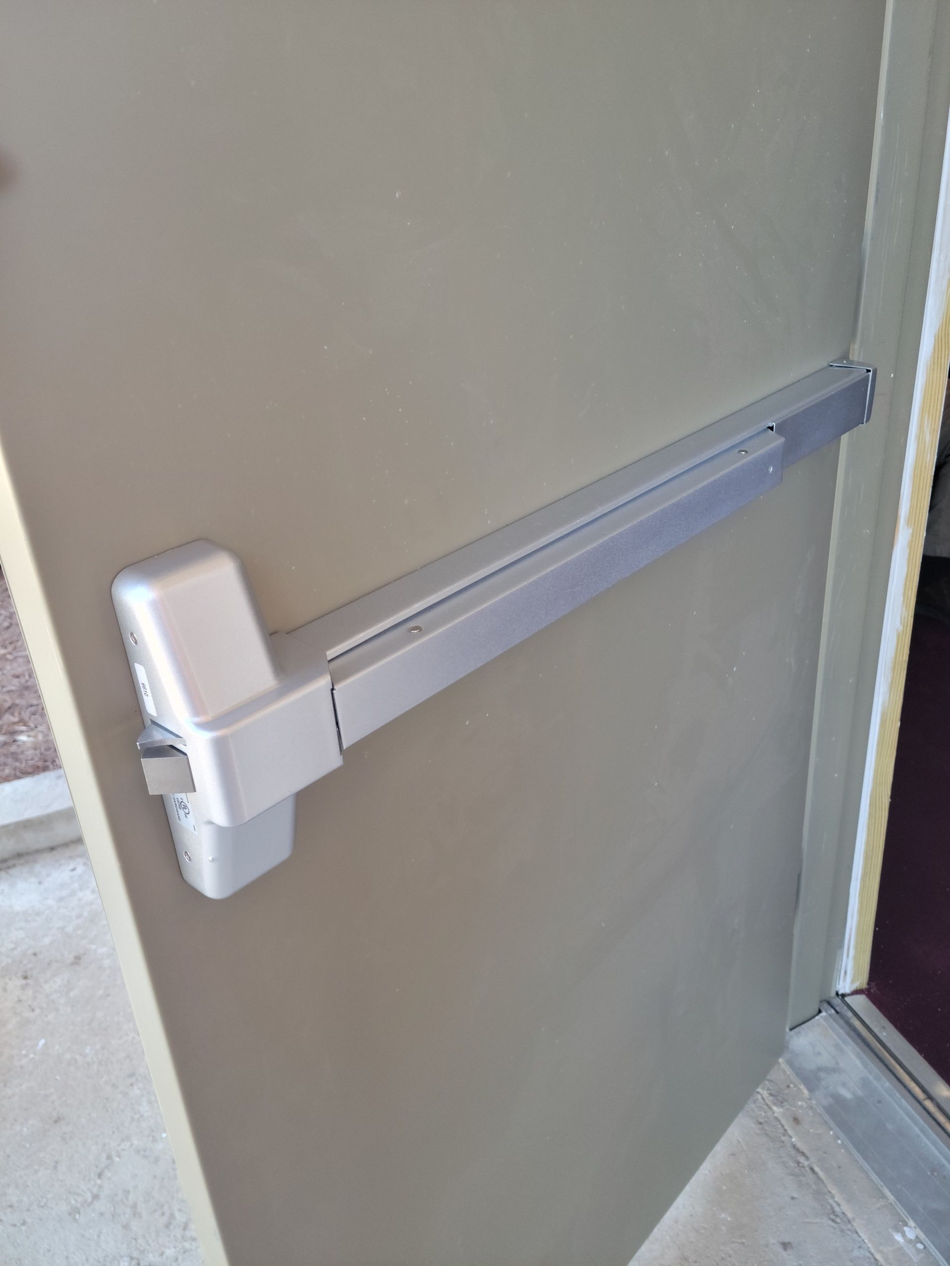A close up of a door with a panic bar on it.