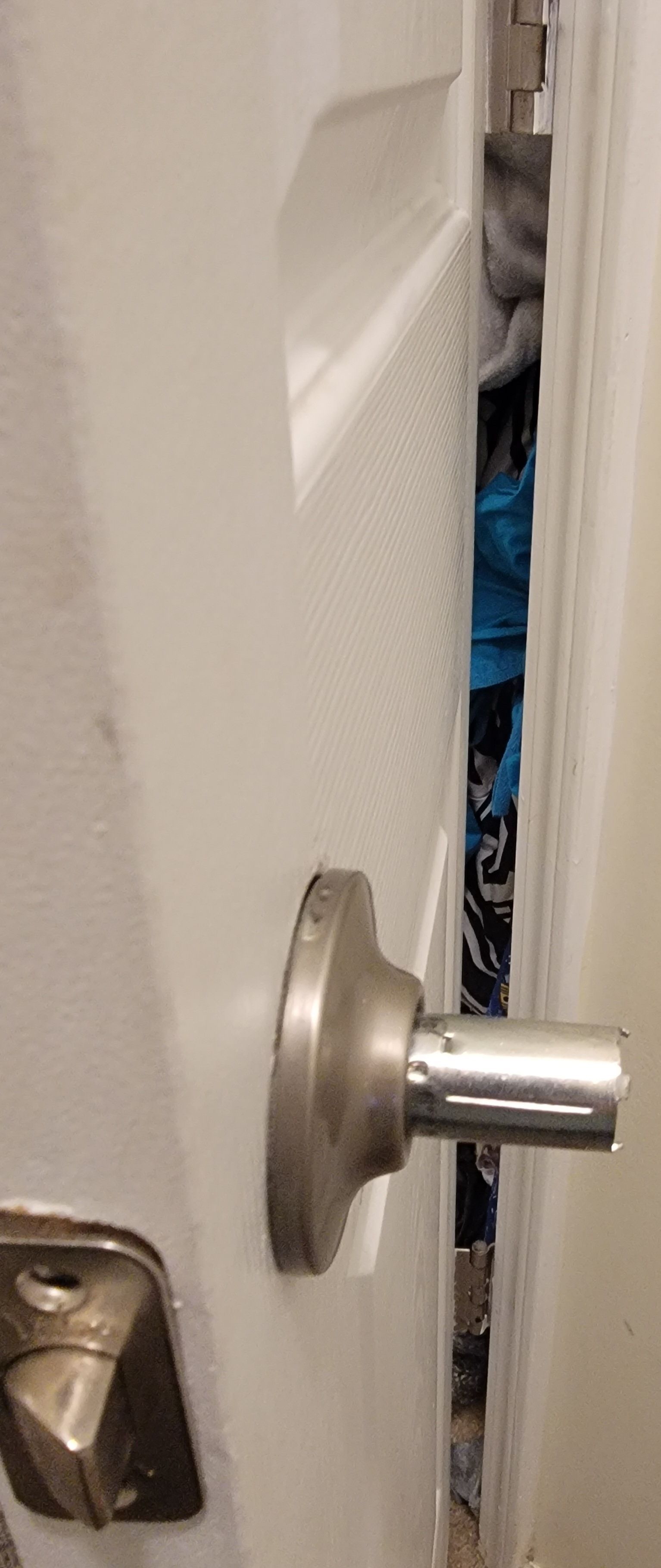A close up of a door handle in a bathroom.
