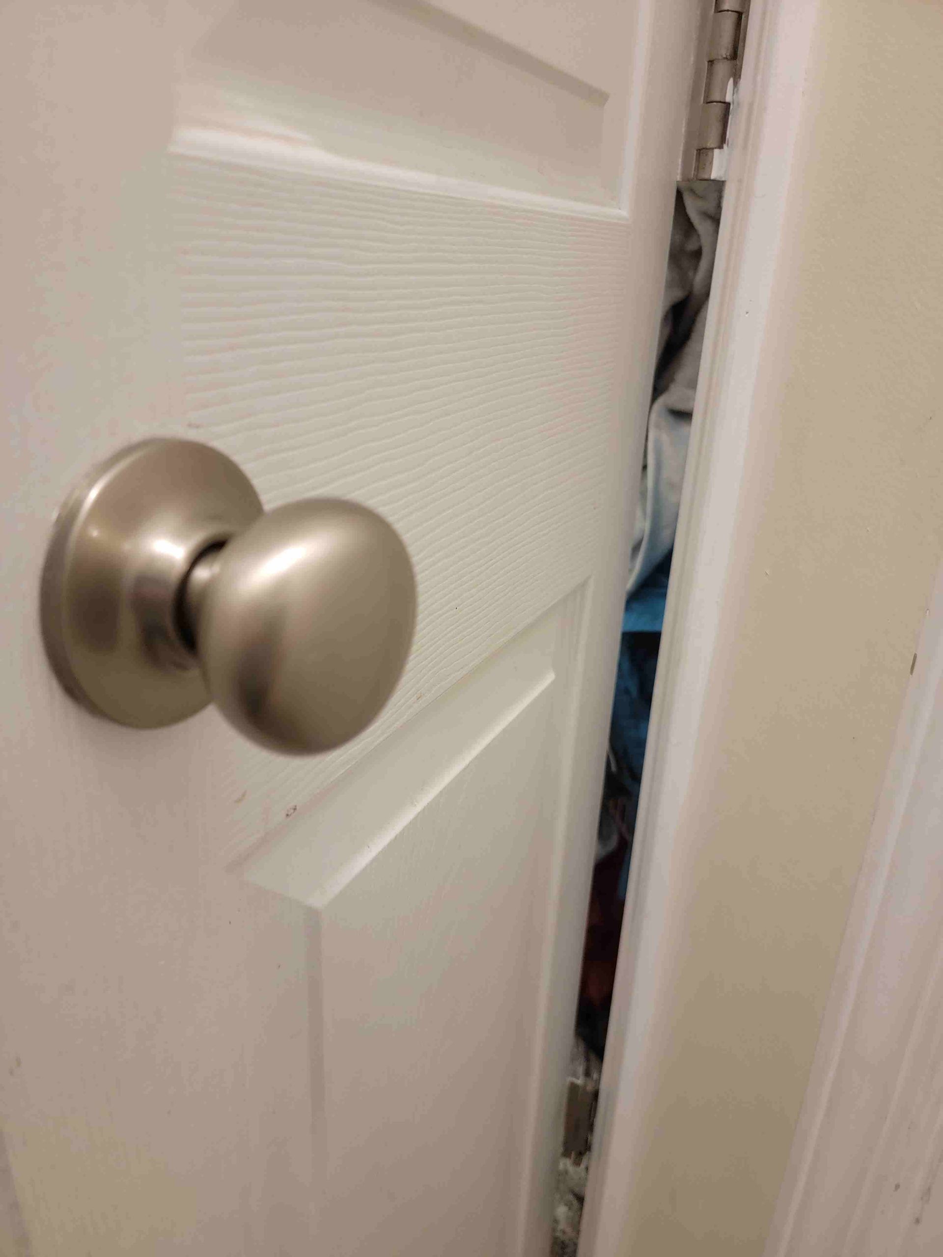 A close up of a door knob on a white door.
