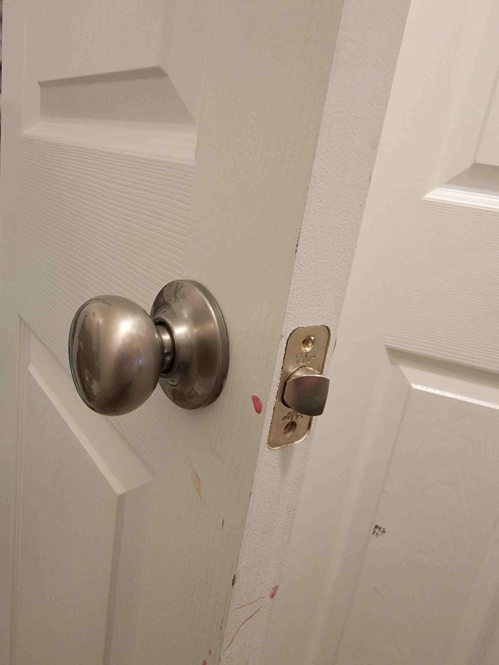 A close up of a door knob on a white door.