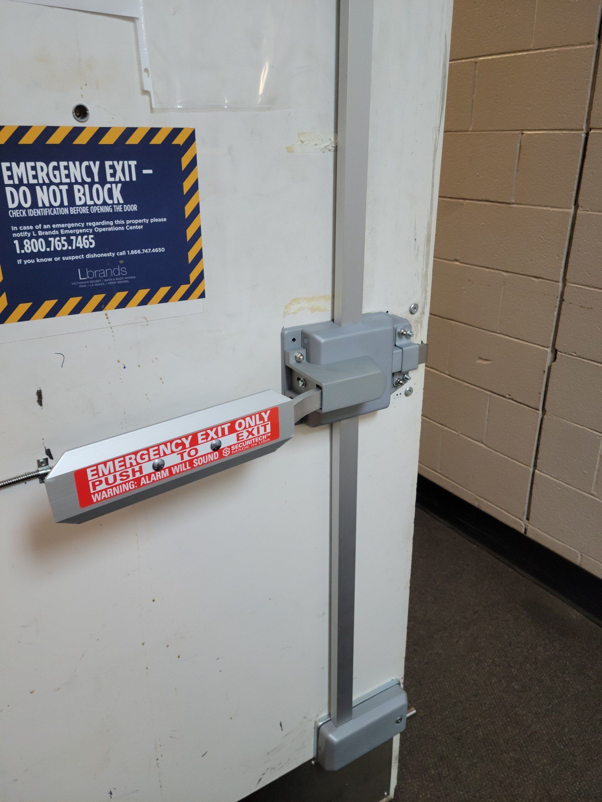 A white door with an emergency exit sign on it