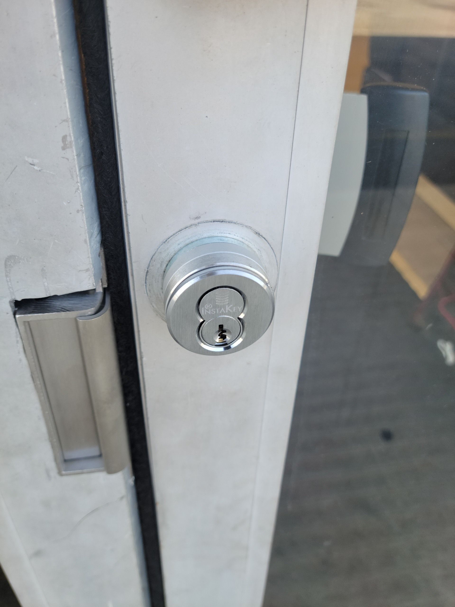 A close up of a door lock on a glass door.