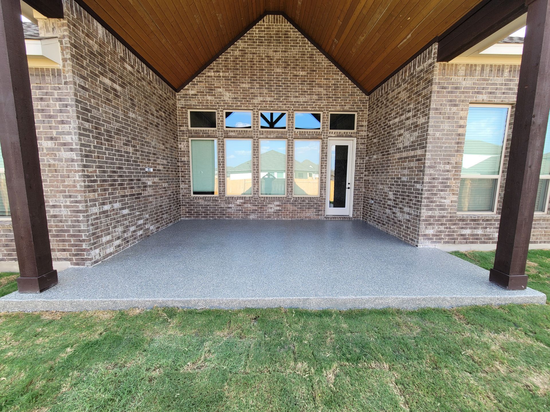 a large brick house with a covered patio in front of it .