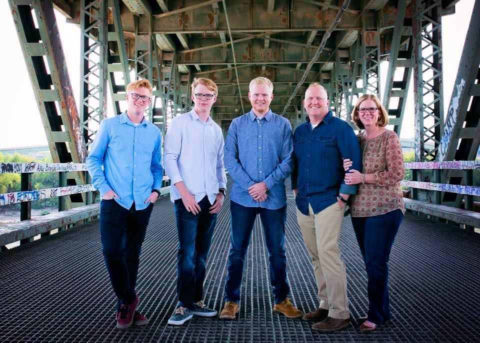 a family is posing for a picture on a bridge .