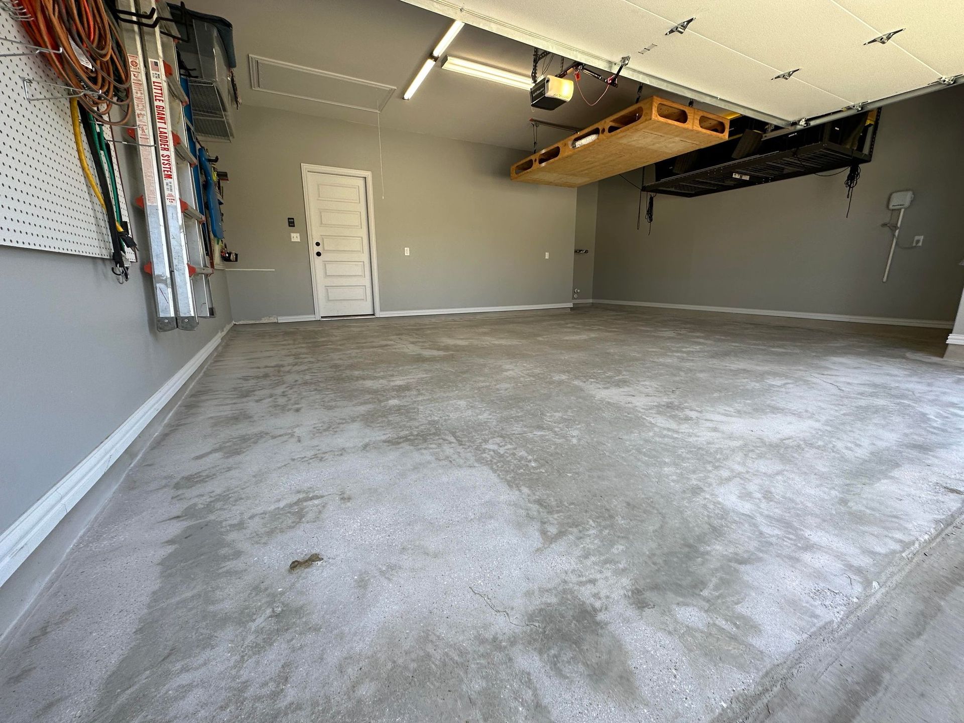 an empty garage with a concrete floor and a garage door open .