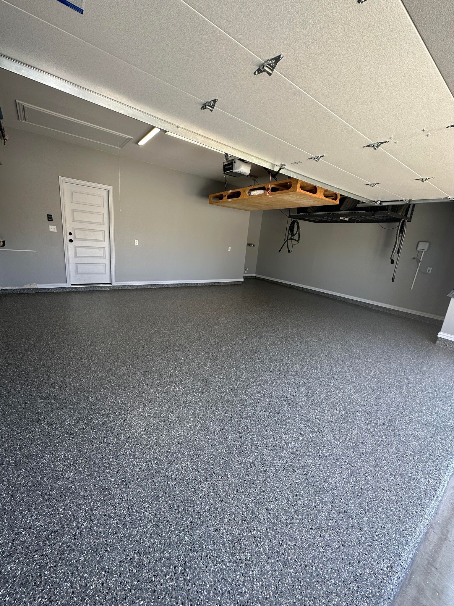 a garage with a gray floor and a white door .