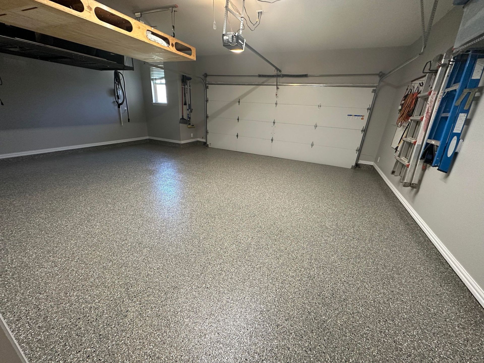 a garage with a garage door open and a ladder on the wall .