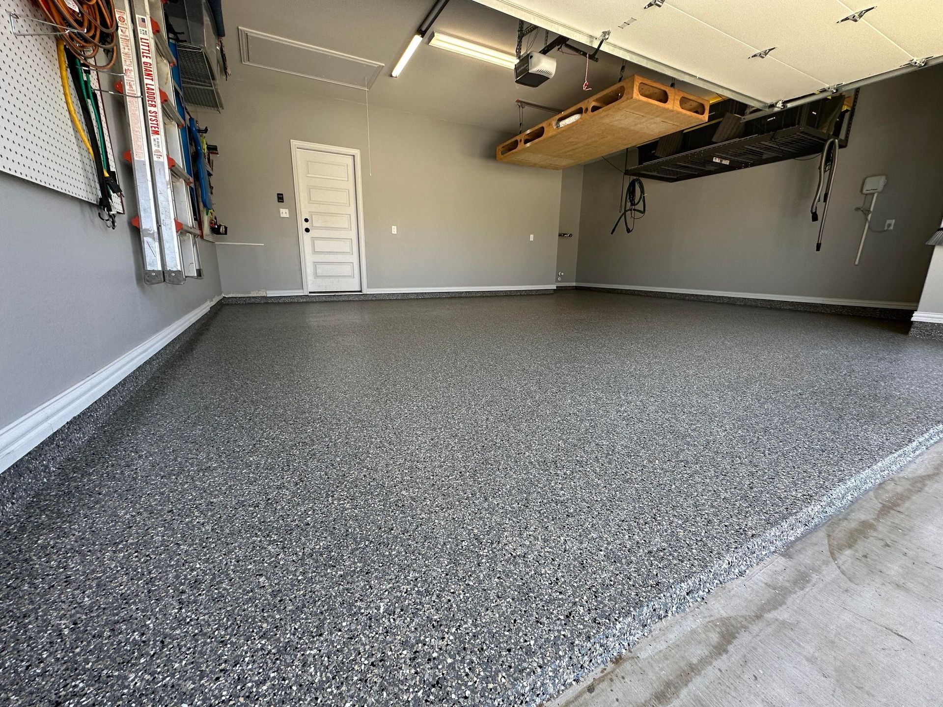 a garage with a garage door open and a gray floor .