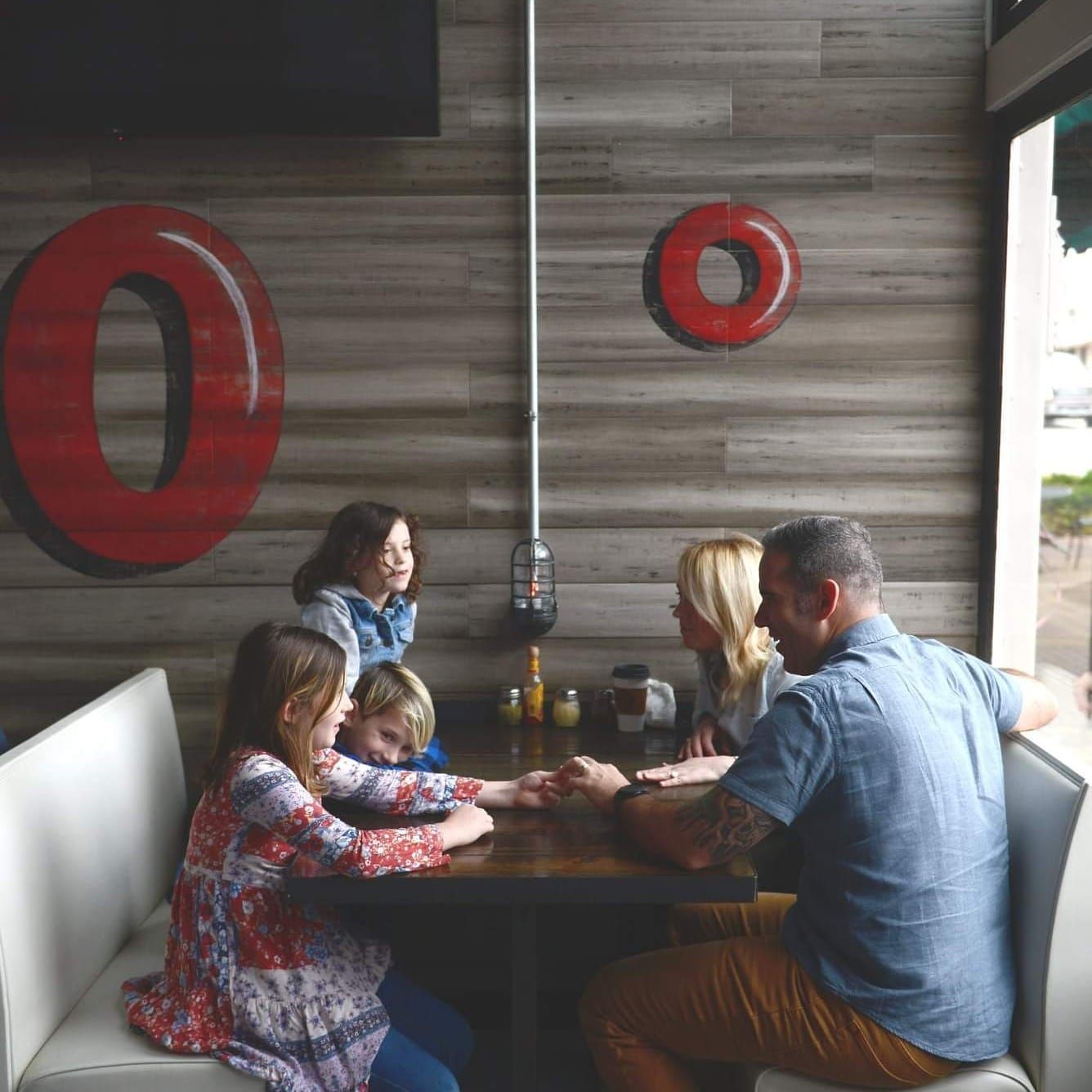 a family are sitting at a table in a restaurant