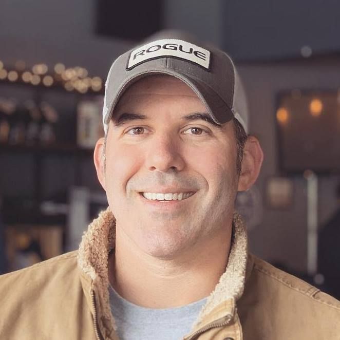 a man wearing a hat is smiling for the camera