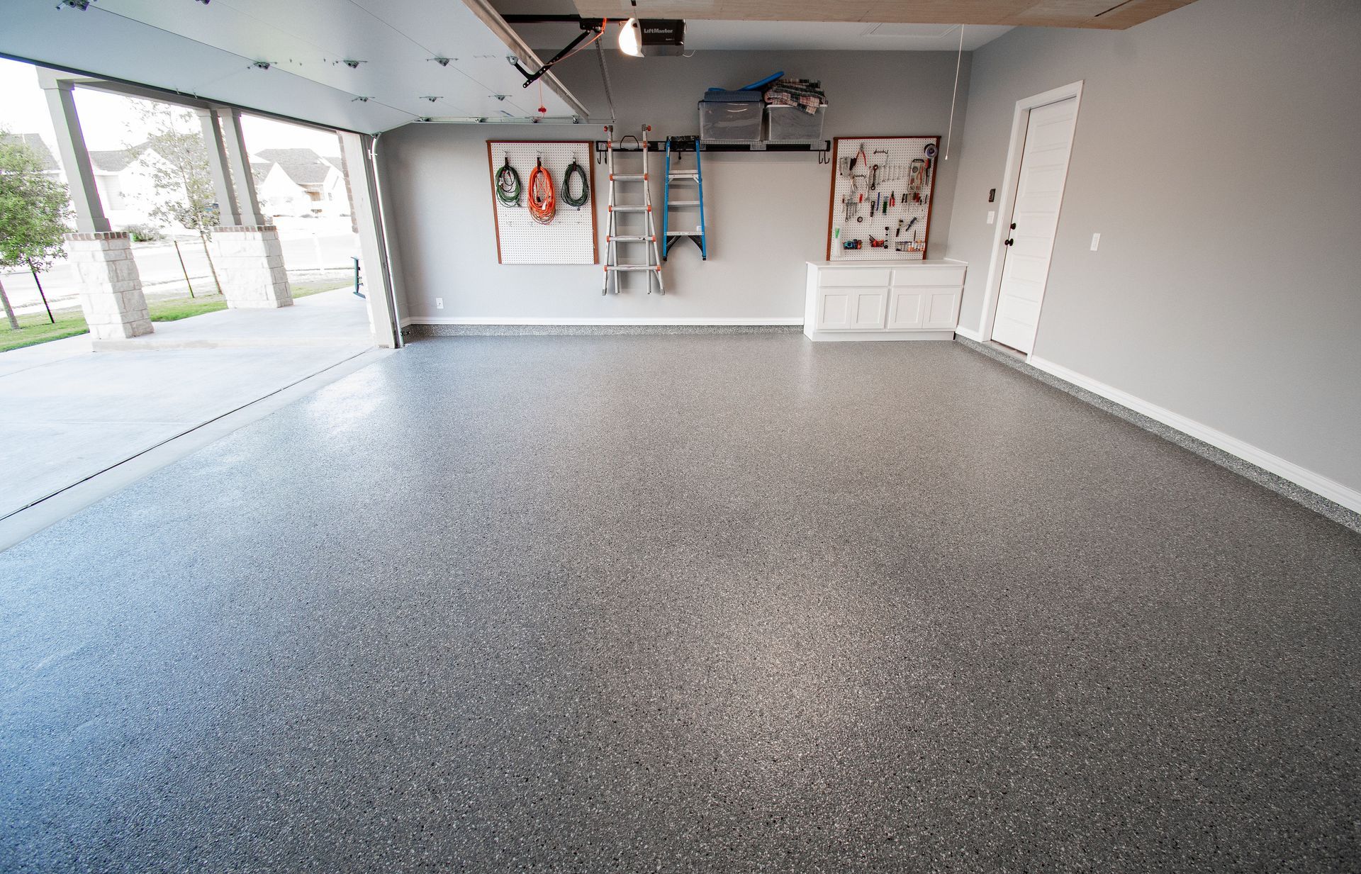 a garage with a gray floor and a ladder on the wall