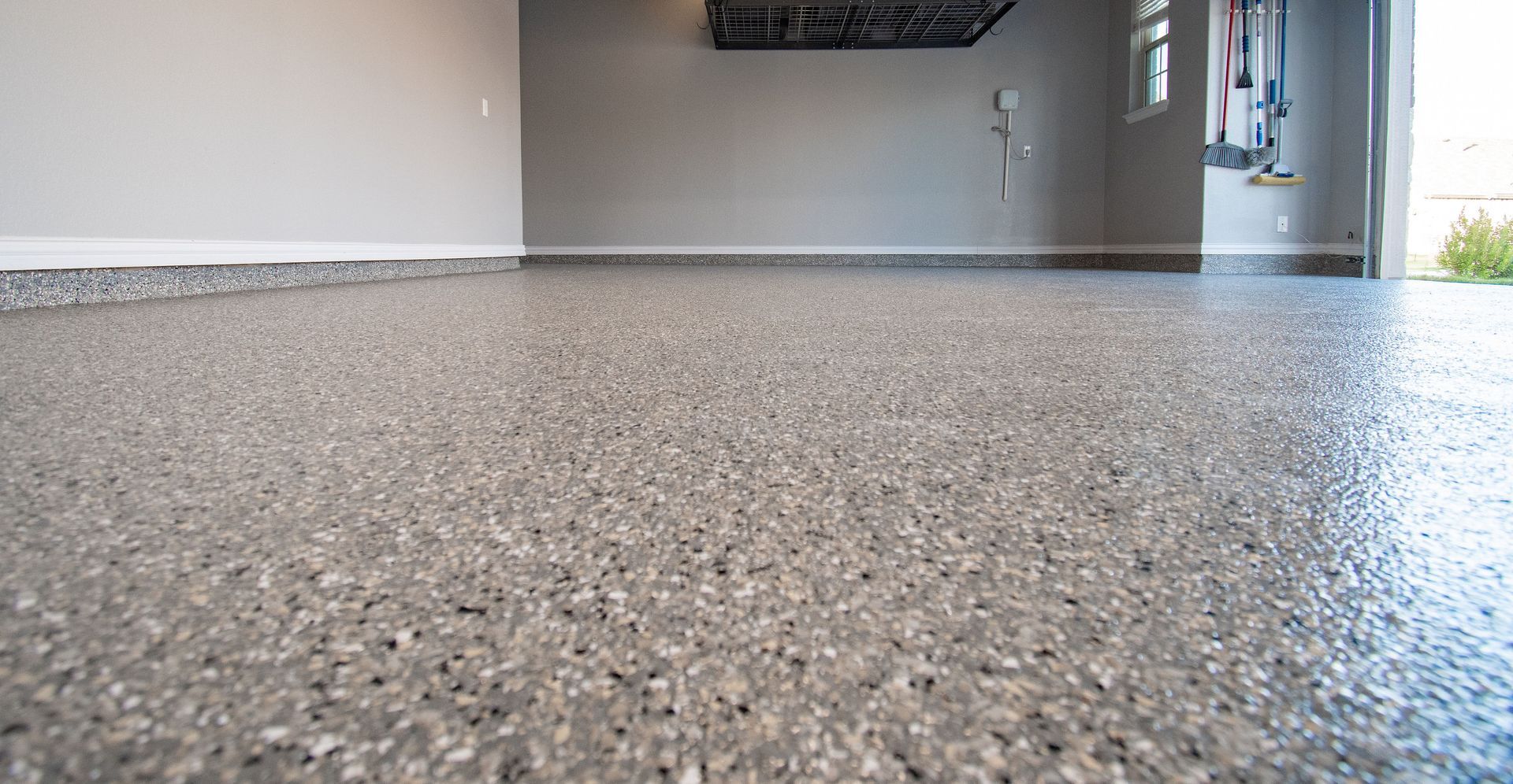 a garage with a gray concrete floor and a gray wall .
