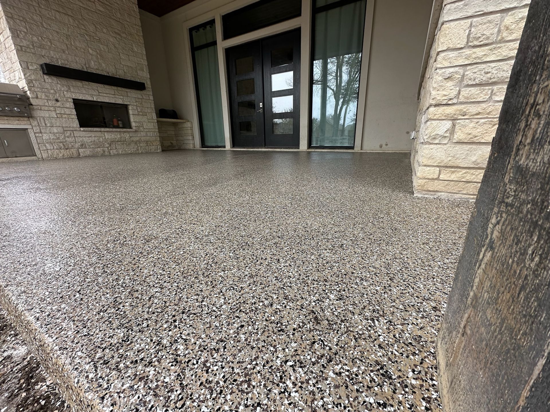 a patio with a concrete floor and a fireplace .