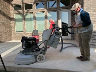 a man wearing a mask is using a machine to polish concrete .