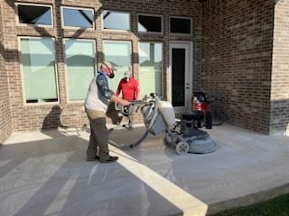 a man is using a concrete grinder to grind a concrete patio.