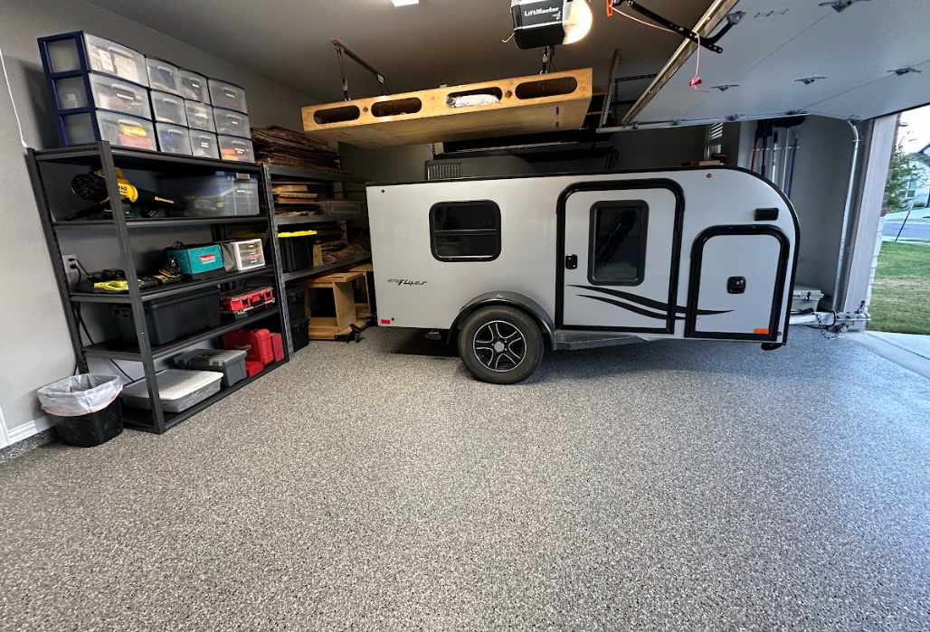 a trailer is parked in a garage with a garage door open .