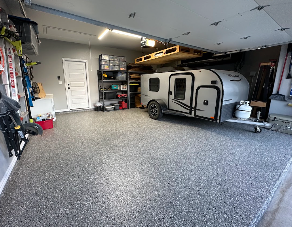 a trailer is parked in a garage with a garage door open
