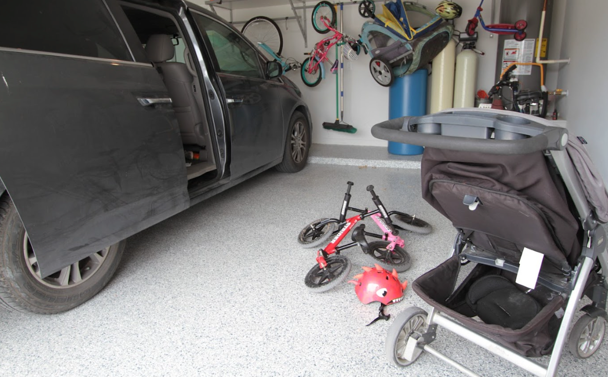 a stroller is sitting in a garage next to a car.