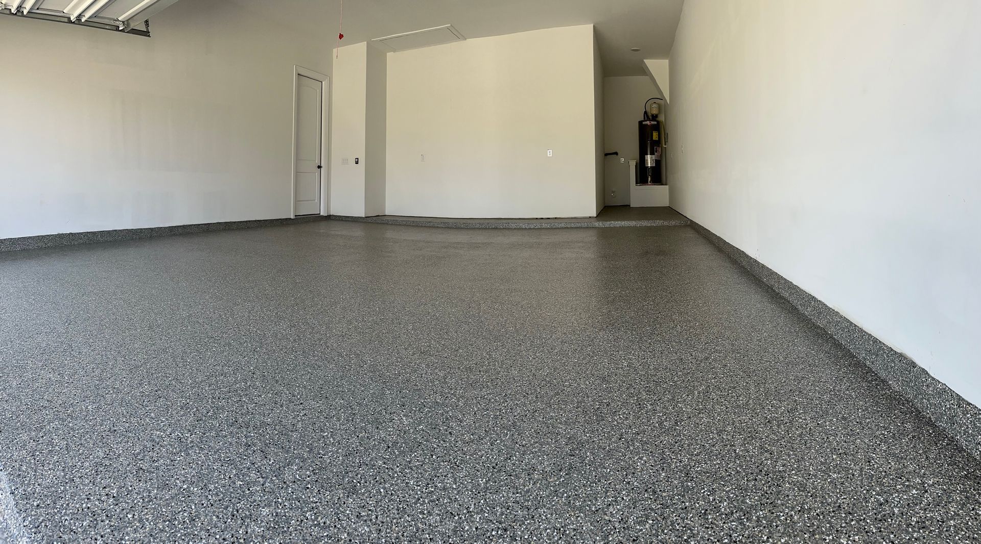 a garage with a gray floor and white walls .