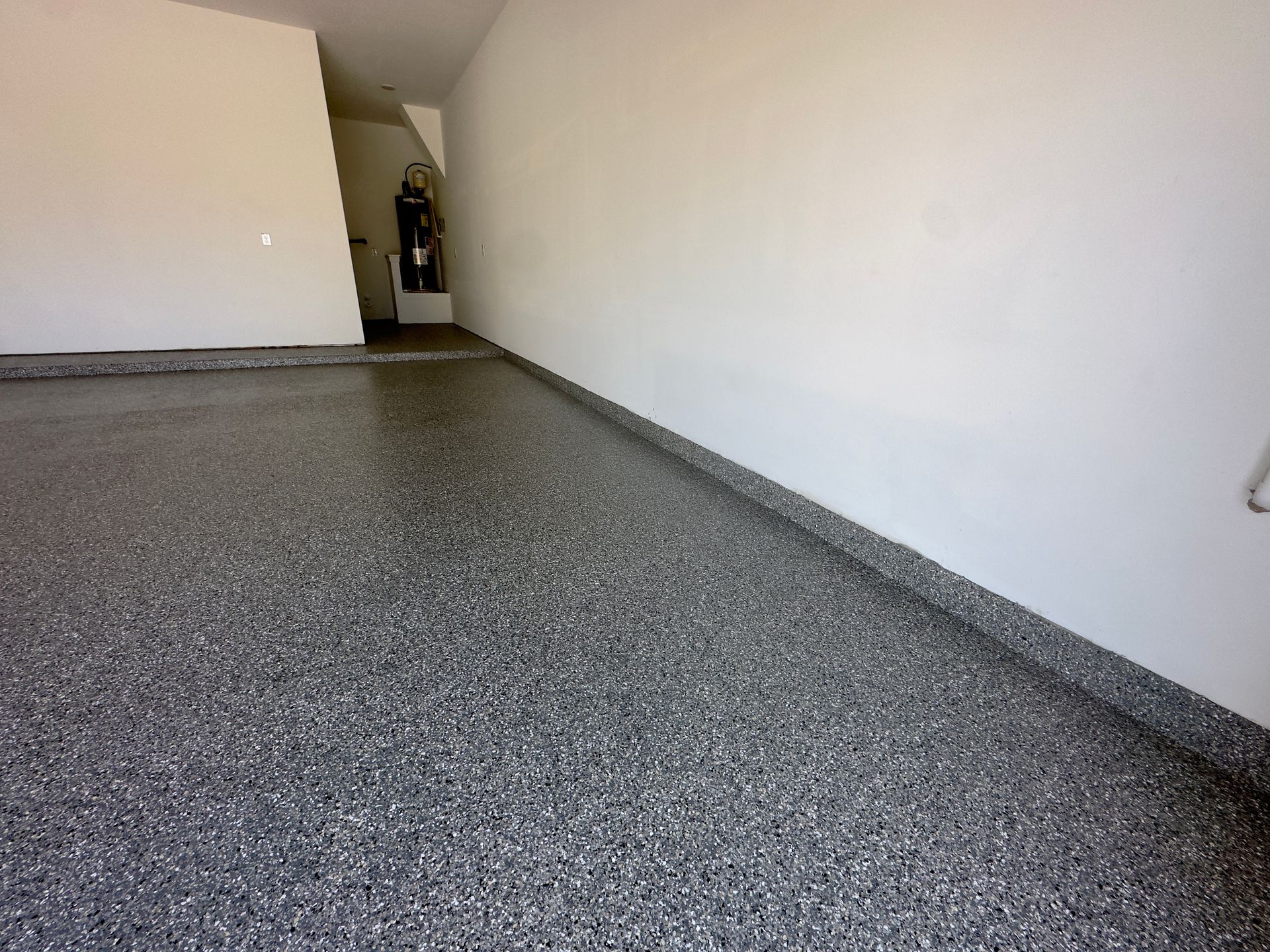 a garage with a gray floor and white walls