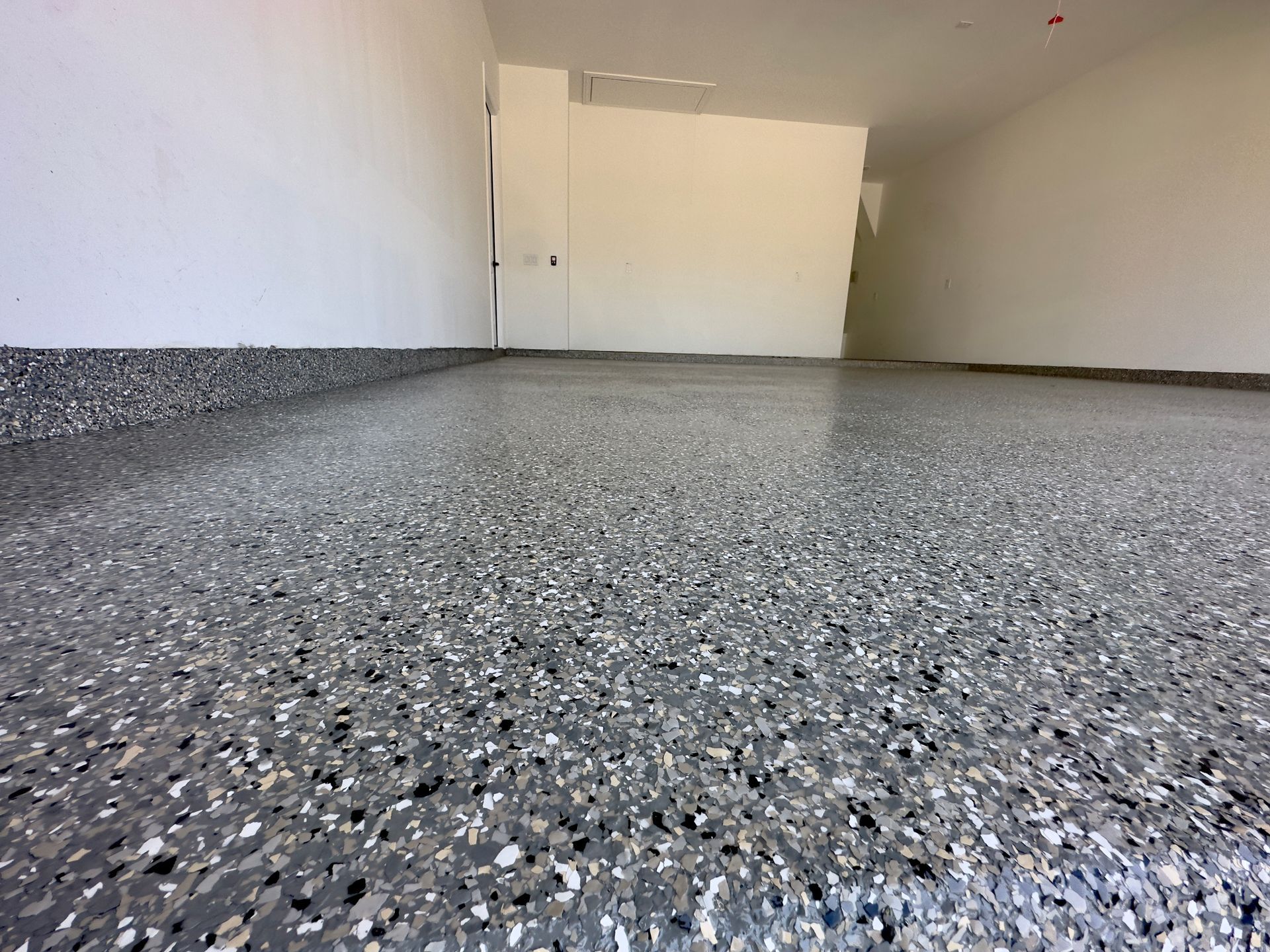 a garage with a gray floor and white walls