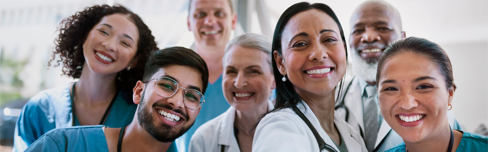 A diverse group of healthcare professionals smiling together in a clinical setting.