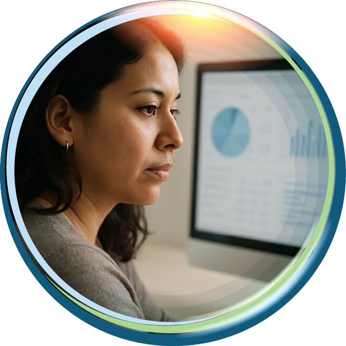 A person focused on a computer screen displaying data charts and graphs.