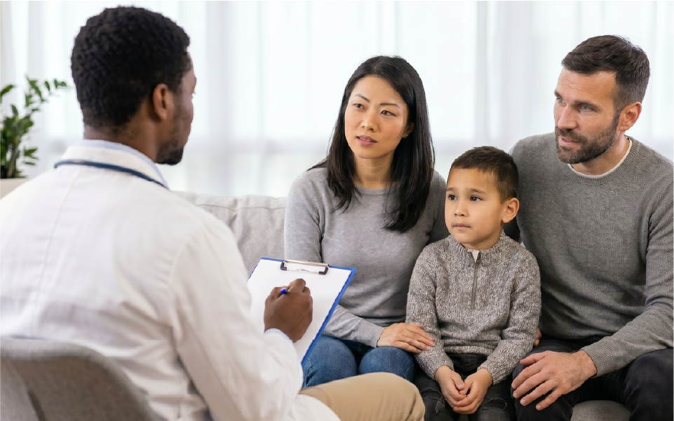 Healthcare worker in blue gloves checks a child’s arm while seated in a bright clinic.