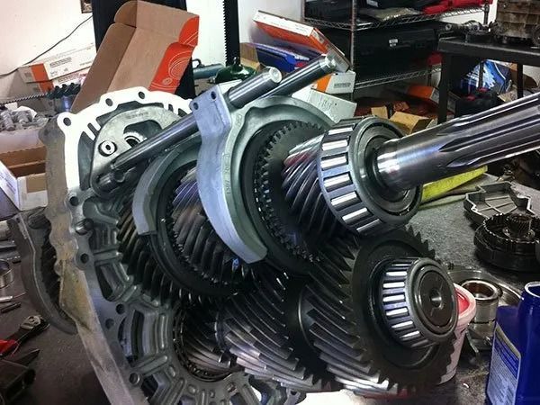 Open transmission gears, partially assembled, on a workbench.