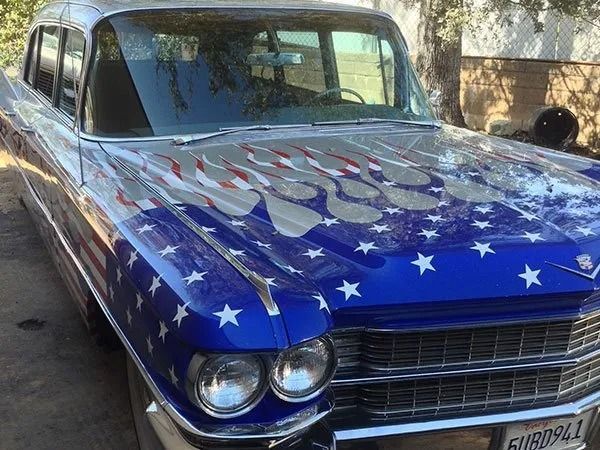 Cadillac car with patriotic flame design. Blue, silver, and white paint. Front view.