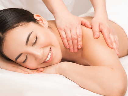 Person receiving a back massage with a handheld device on a spa table Person receiving a back massage with a handheld device on a spa table